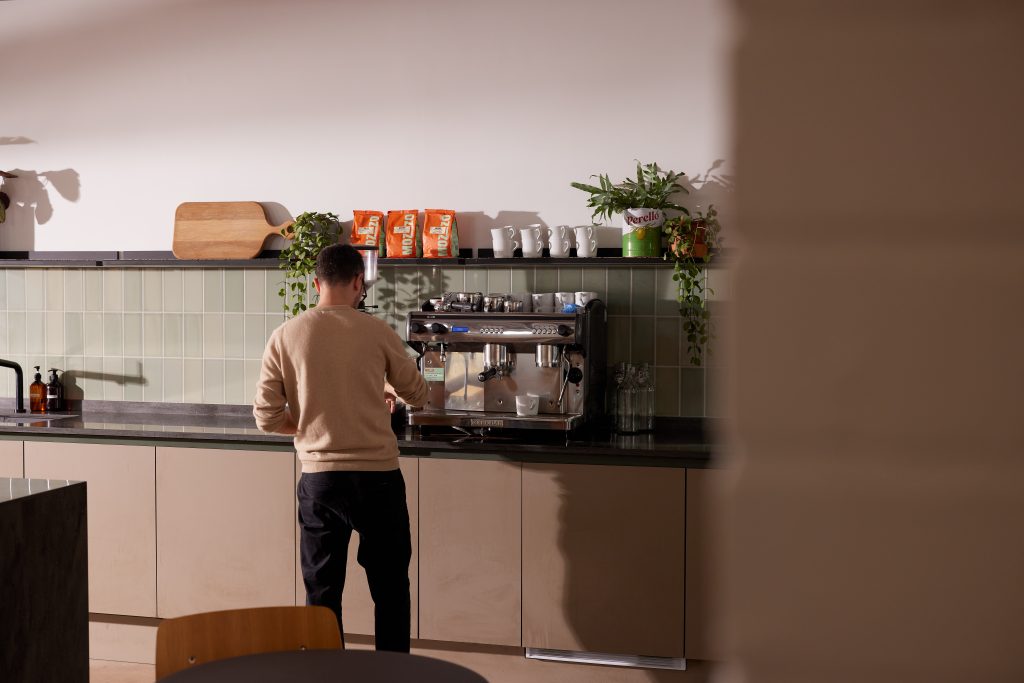 A man stood in front of a barista coffee machine in a modern kitchen