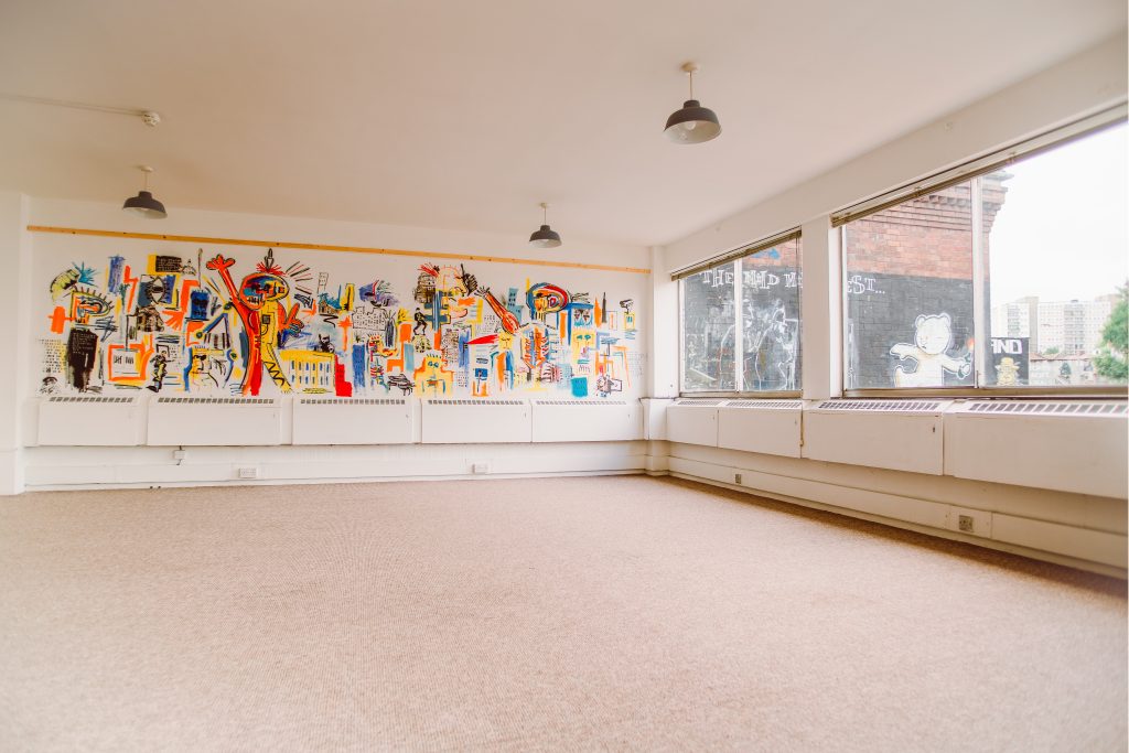 A large well-lit room with abstract paint on the walls