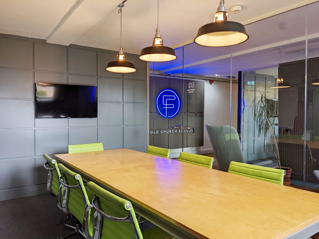 Meeting room with tables, chairs, and TV