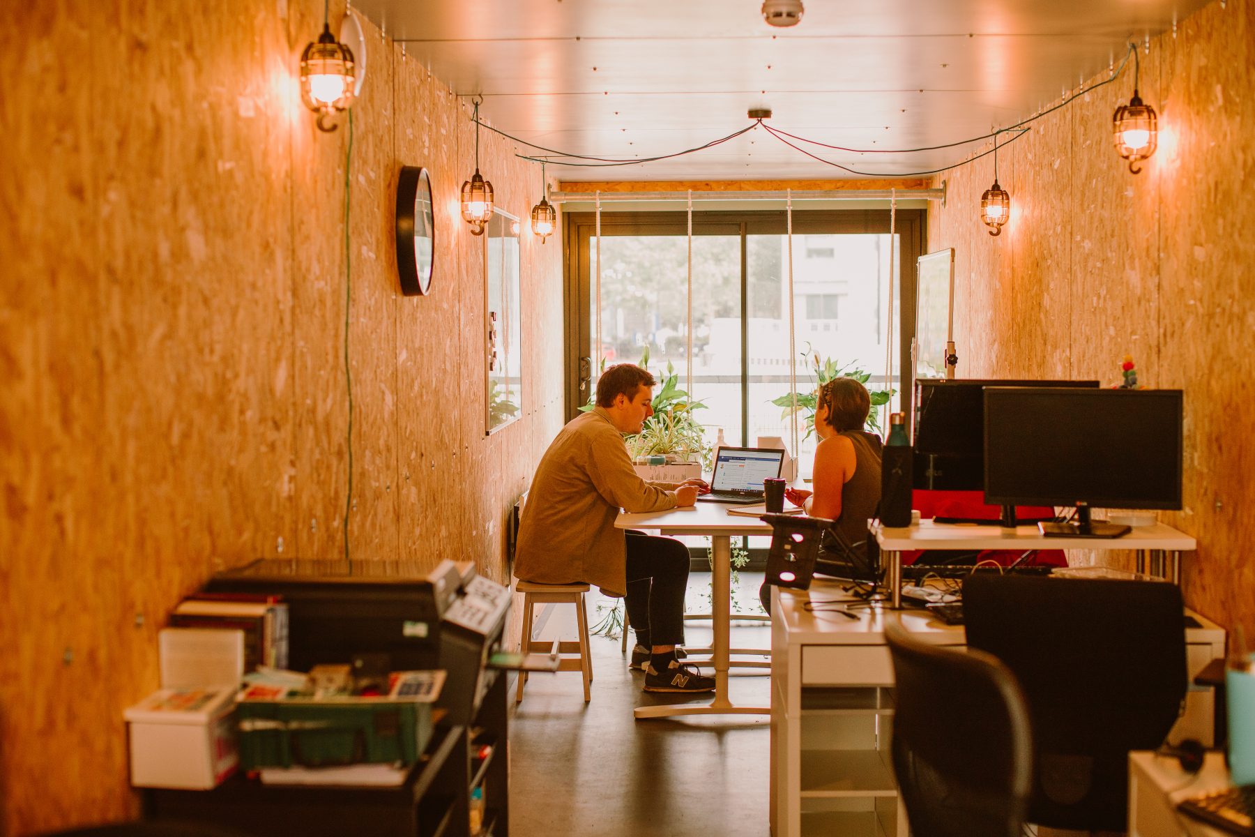 Two people sat working at a desk in an office space