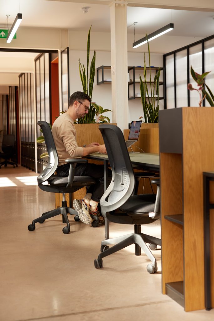 Man sat at a wooden desk working