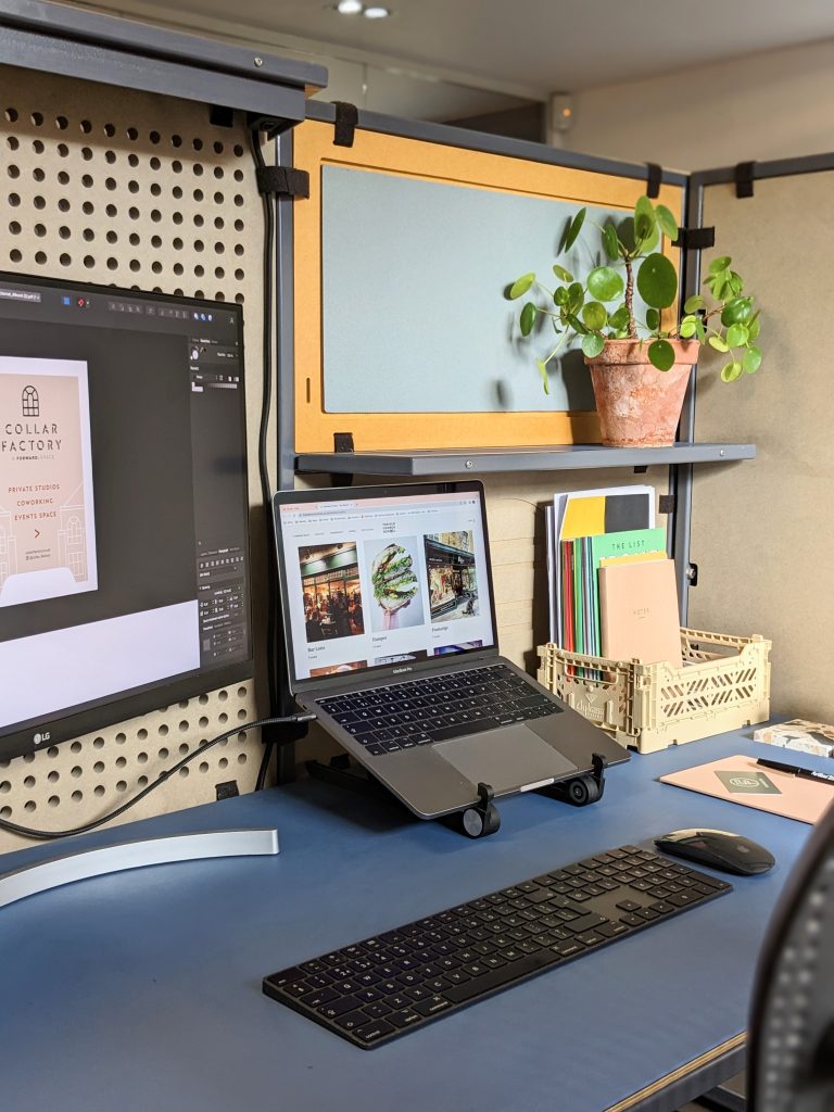 A desk with a laptop, keyboard and monitor.