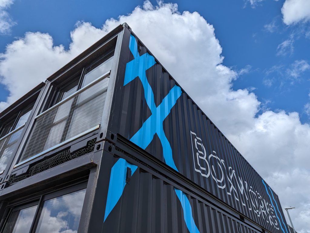 A black shipping container, stacked.