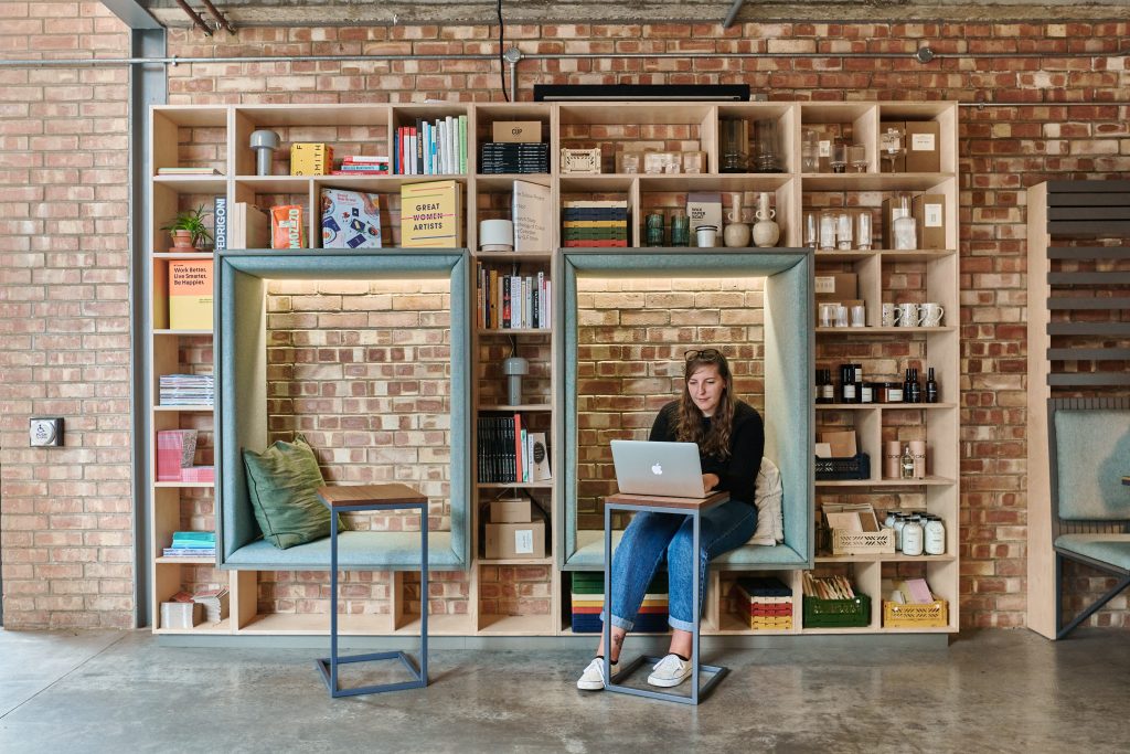 A woman sat working in front of a Mac laptop